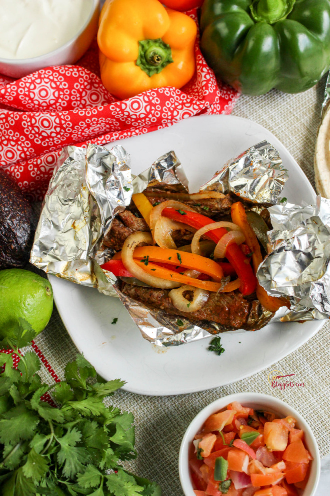 white plate with grilled steak fajita packets