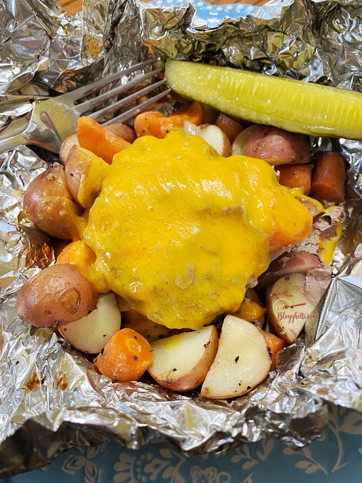 delicious cheeseburger, potatoes and carrots dinner with pickle