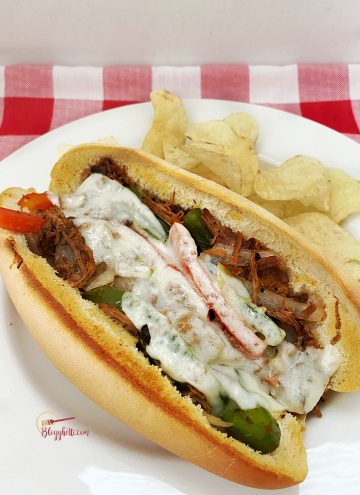 easy philly cheesesteak sandwich with chips on white plate