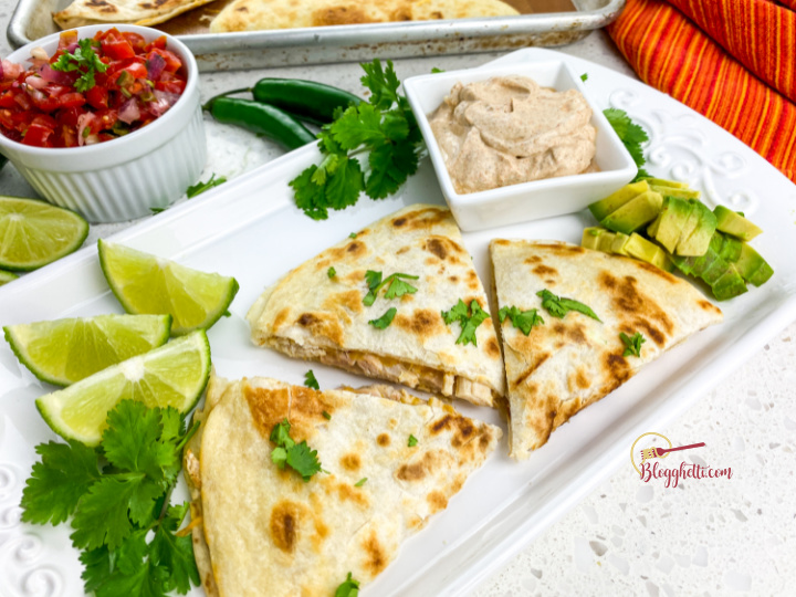 serving platter with rotisserie chicken quesadilla and toppings