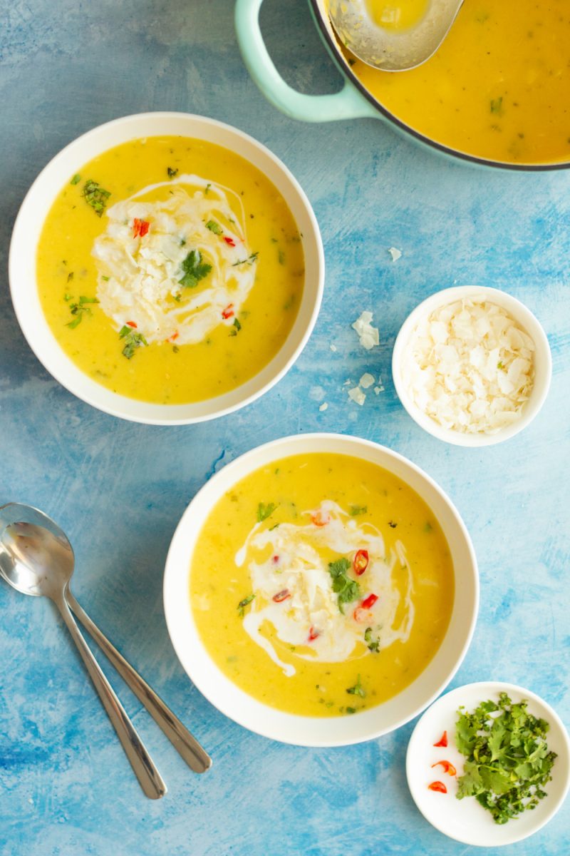 overhead view of two white bowls filled with creamy butternut squash soup