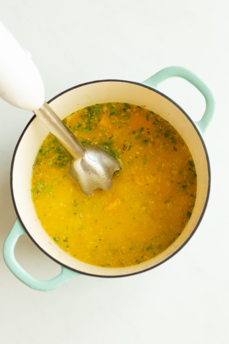 pureeing the soup with an immersion blender