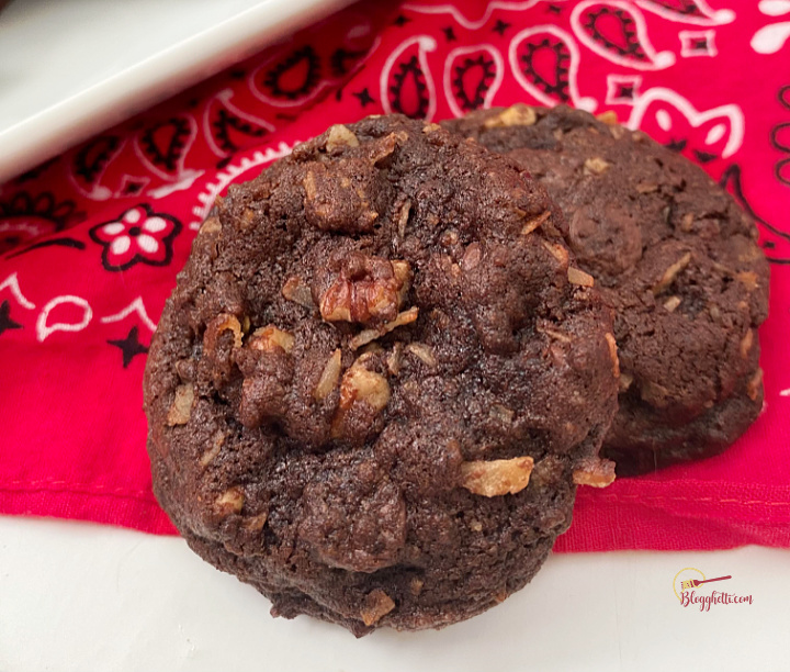 close up of two German chocolate cookies on red towel