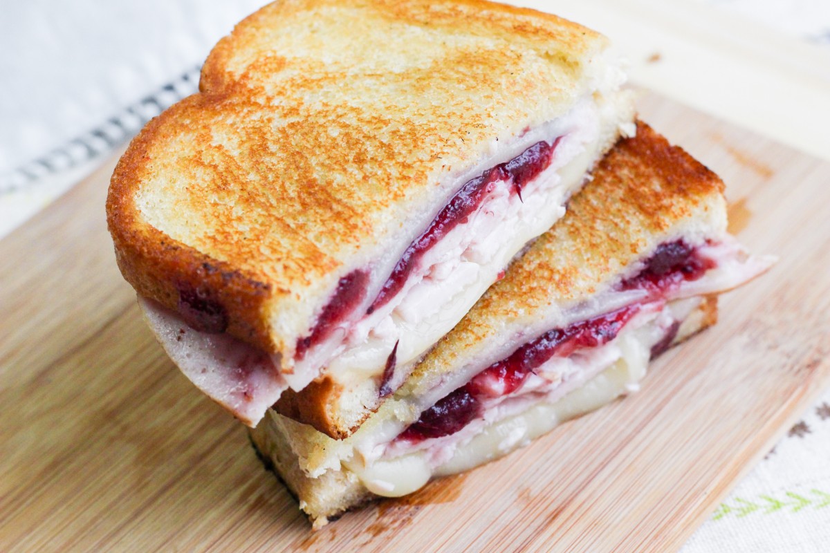 turkey and cranberry grilled cheese sandwich on cutting board