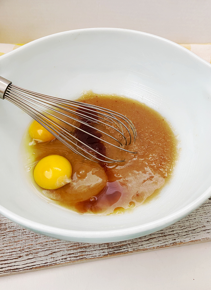adding eggs with sugar mixture in bowl
