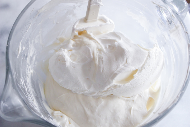 adding marshmallow fluff to cream cheese in bowl