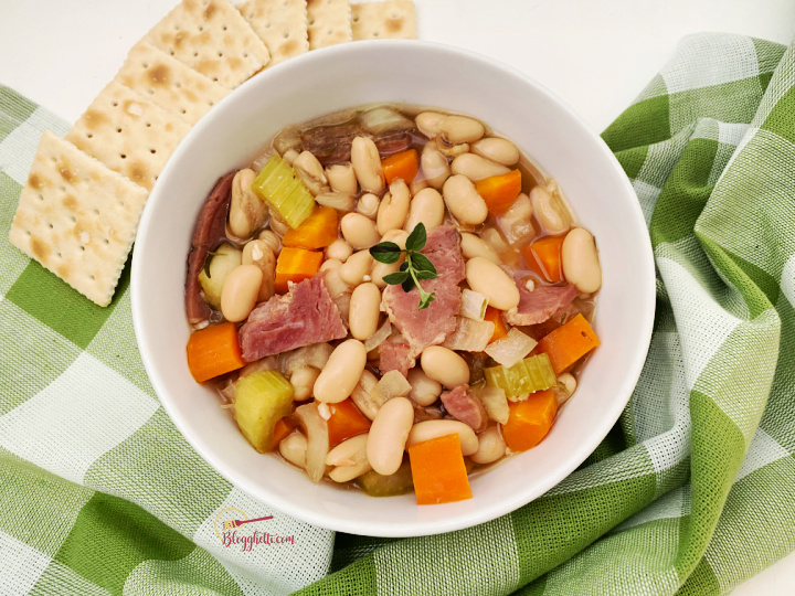 close up of white bowl filled with ham and white bean soup