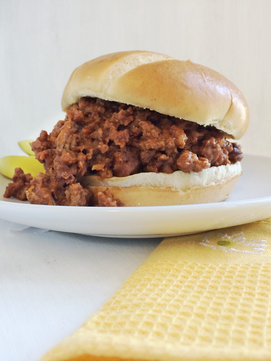 homemade sloppy joe sandwich on plate with pickles