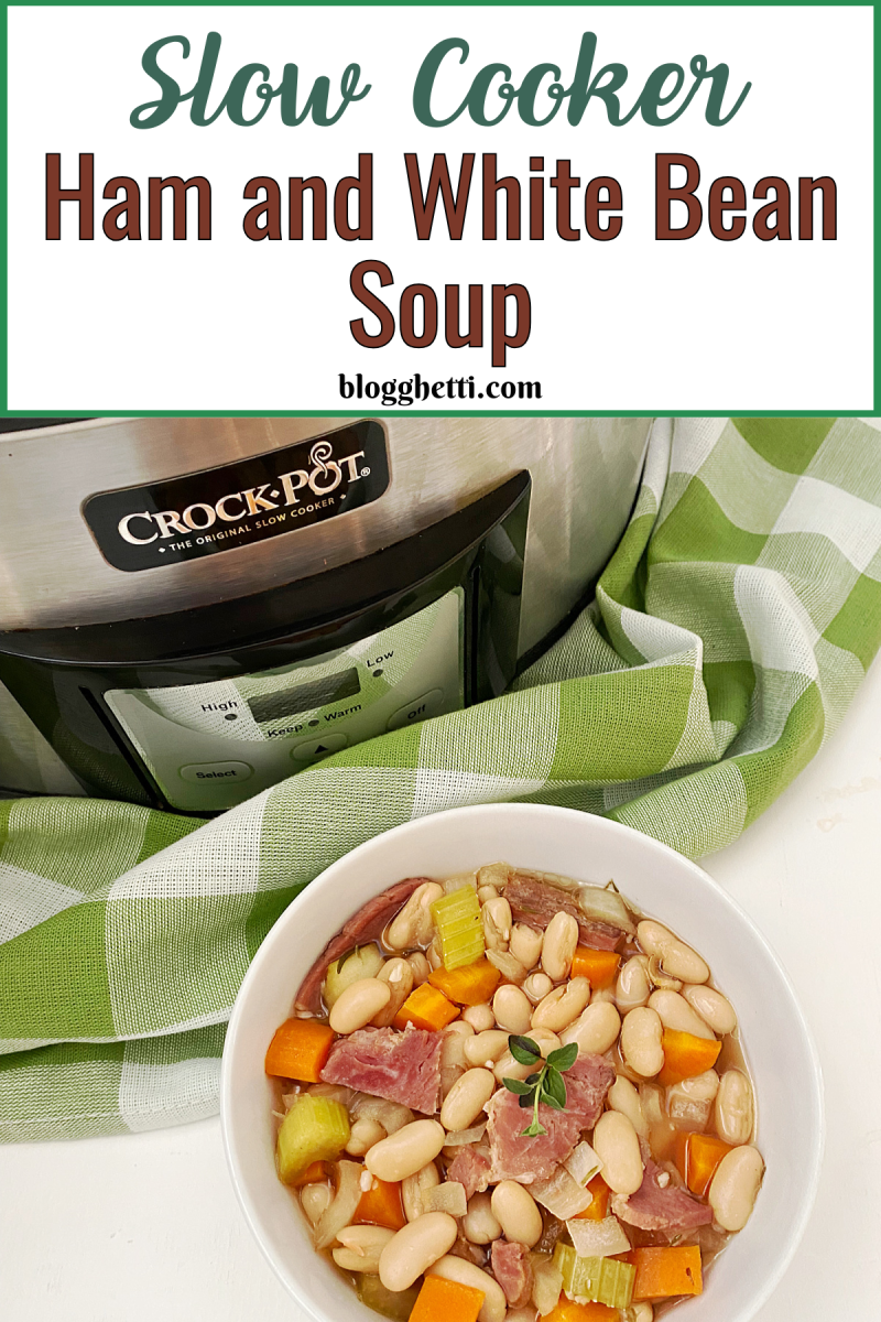 A bowl of hearty Slow Cooker Ham and White Bean Soup sits on a green and white checkered napkin, with a Crock-Pot slow cooker visible in the backgroA bowl of hearty Slow Cooker Ham and White Bean Soup sits on a green and white checkered napkin, with a Crock-Pot slow cooker visible in the background.