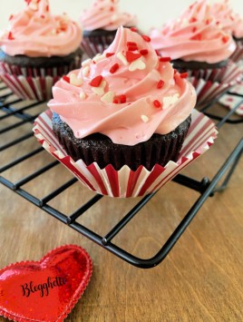 chocolate cupcakes with pink cream cheese frosting and sprinkles