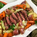 corned beef, cabbage, carrots, and potatoes on white serving platter