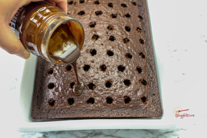 pouring hot fudge into holes of chocolate cake