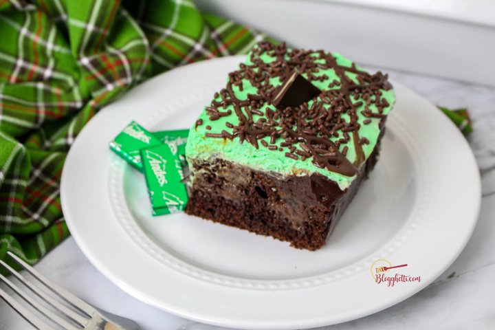 slice of chocolate mint poke cake on white plate with fork