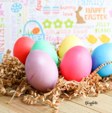 Dyed Easter Eggs on wooden board with pastel background