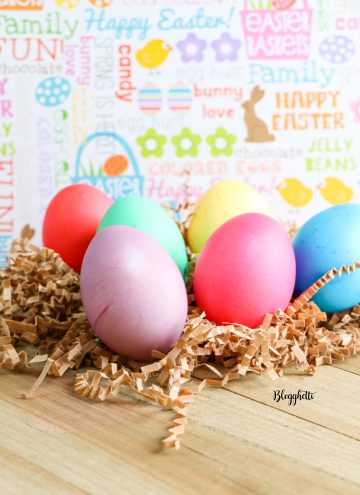 Dyed Easter Eggs on wooden board with pastel background