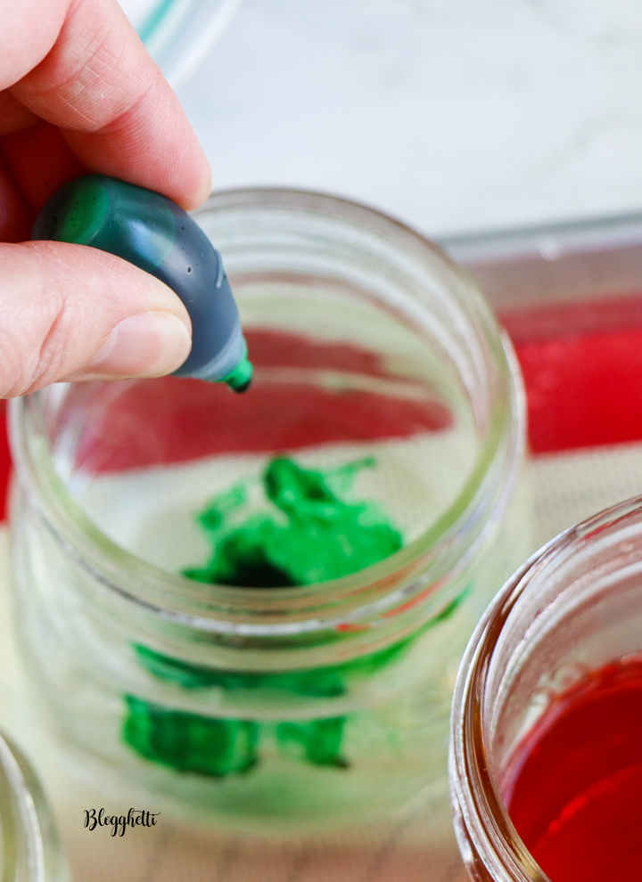 adding food coloring to mason jars with water for dying eggs