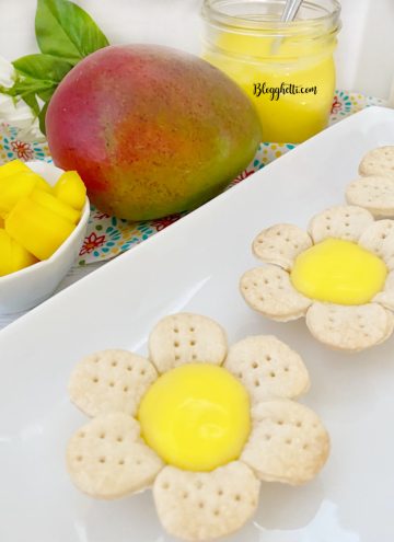 close up of mini mango tarts with fruit in background