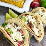 steak street tacos with mexican street corn in background