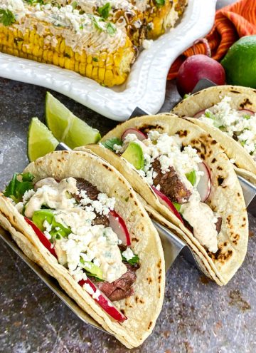 steak street tacos with mexican street corn in background