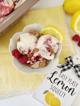 lemon raspberry cheesecake ice cream in bowl with lemons in the background