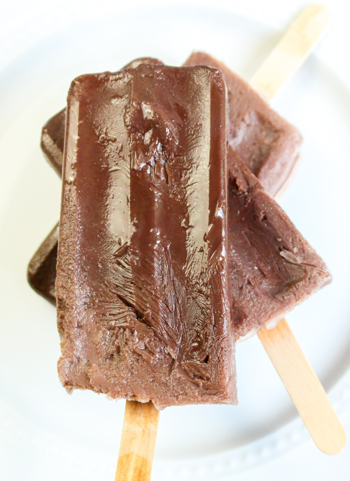Fudgesicles are easy to make and will delight everyone. Close up of three fudgsicles on plate