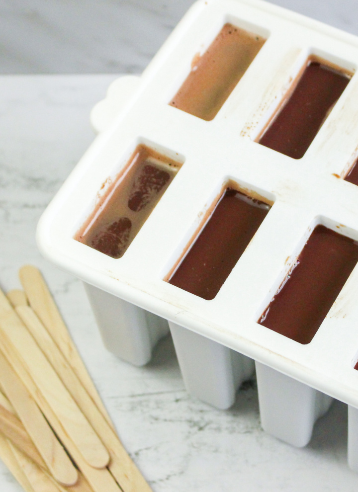 pouring chocolate mixture into popsicle molds
