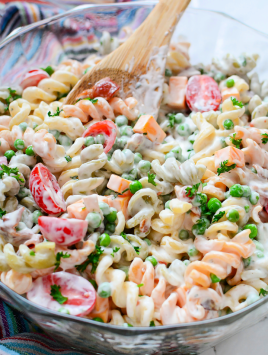 bacon tomato pasta salad in glass serving bowl with wooden spoon