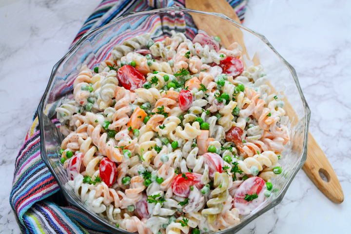 image of serving bowl with creamy bacon tomato macaroni salad on a marble countertop