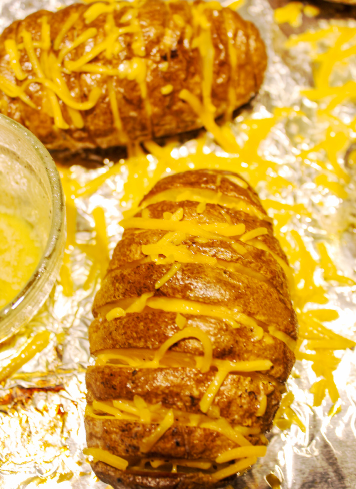baked hasselback potatoes stuffed with shredded cheese
