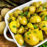 buttered potatoes with parsley in white casserole dish and Instant Pot in background