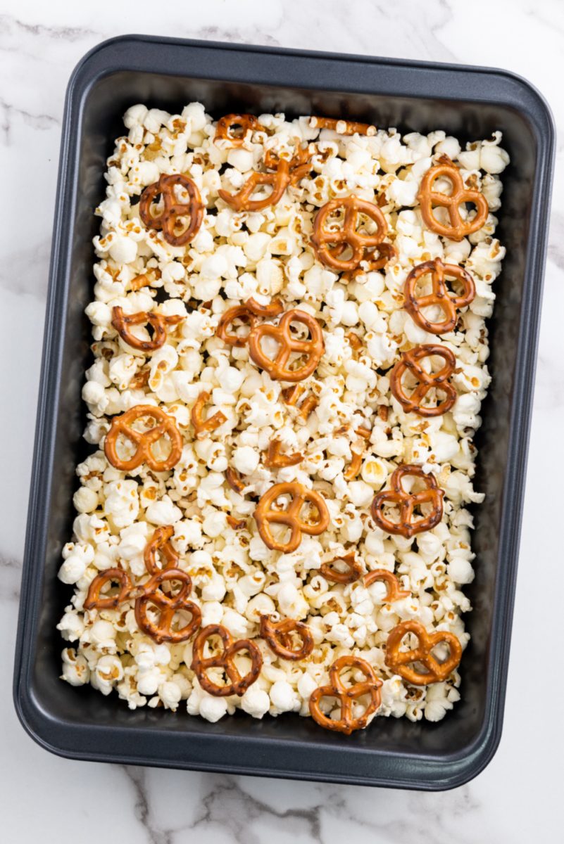 adding pretzels to popcorn