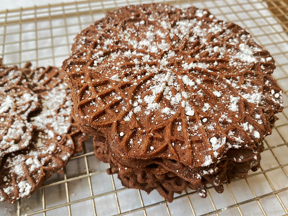 chocolate mint pizzelles dusted with powdered sugar