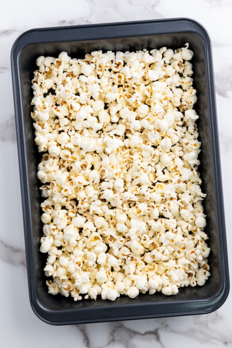 popcorn spread out on baking tray