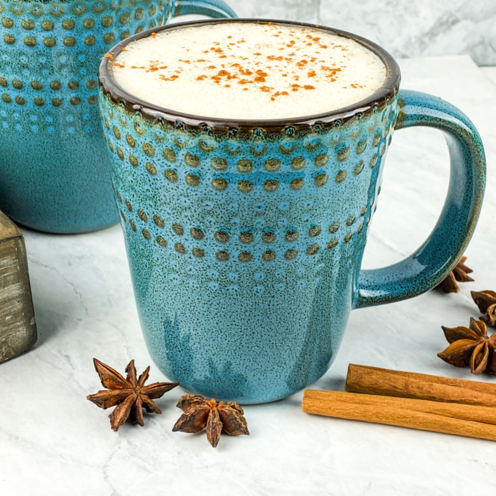 Vanilla Chai lattes in blue mugs with star anise and cinnamon sticks on the side