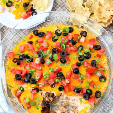 hot baked taco dip overhead view with plate of chips