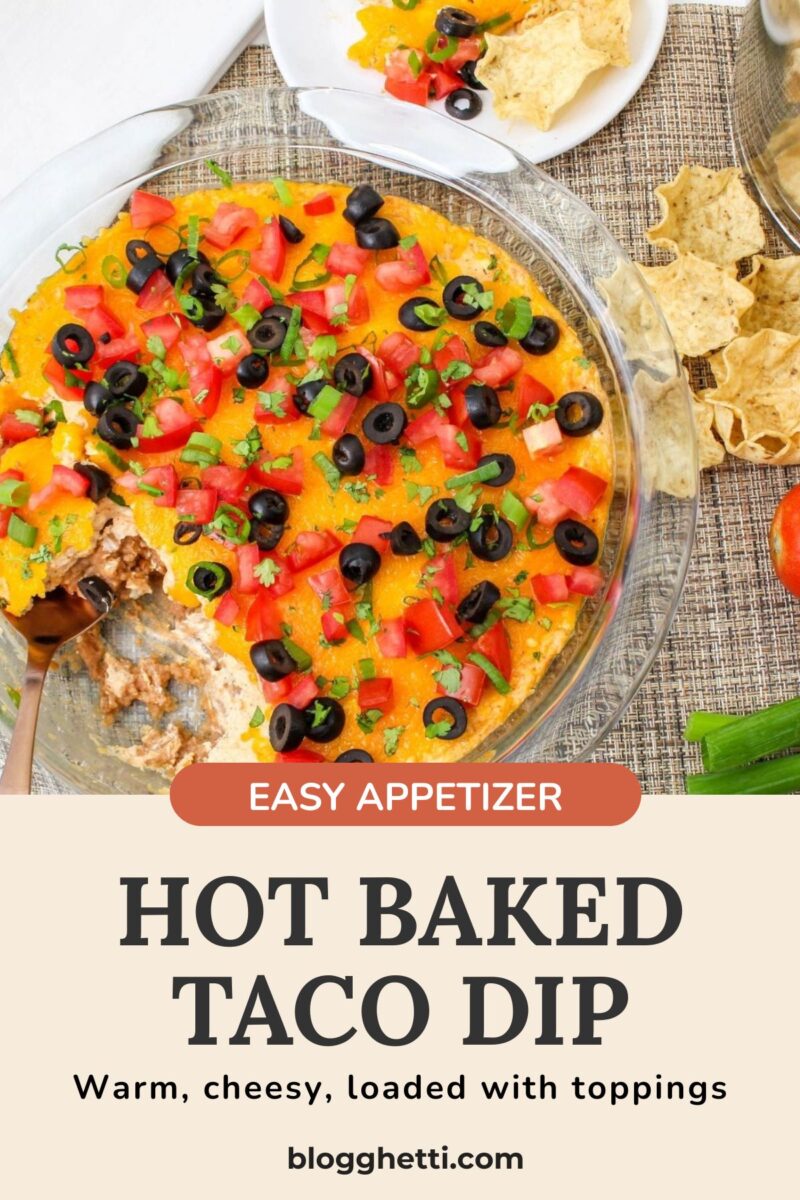 Pin featuring a baked taco dip in a glass dish topped with fresh vegetables and melted cheese with a recipe title overlay.