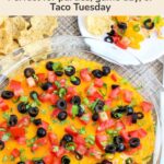 Overhead view of a warm taco dip with melted cheddar and fresh toppings alongside tortilla chips with recipe title and party serving text.
