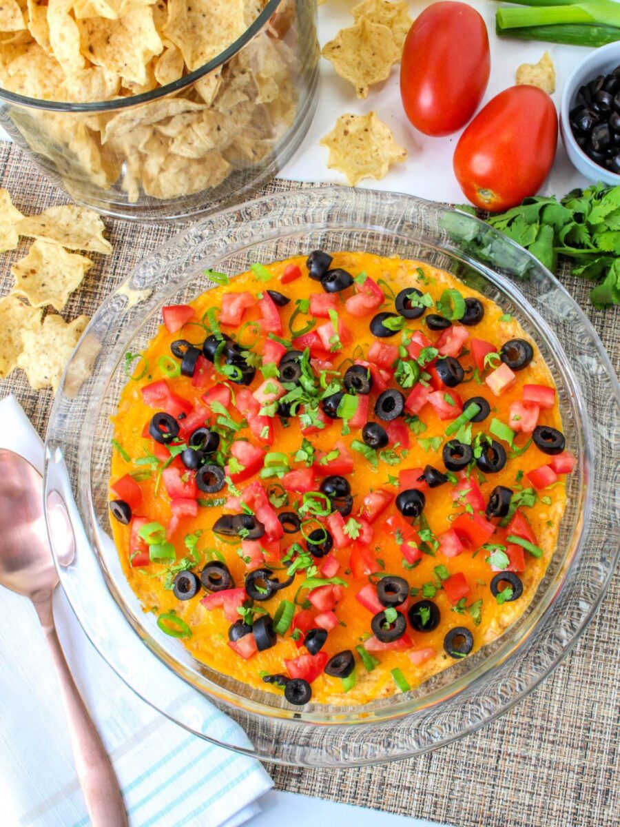 Overhead view showing the dip before baking with melted cheese and after adding fresh toppings for serving.