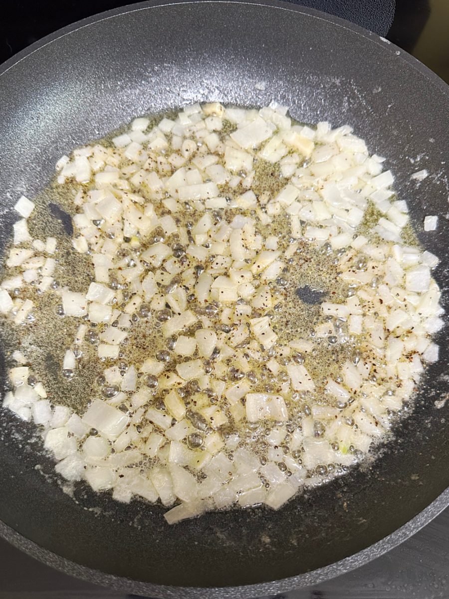 adding seasonings to onions in skillet