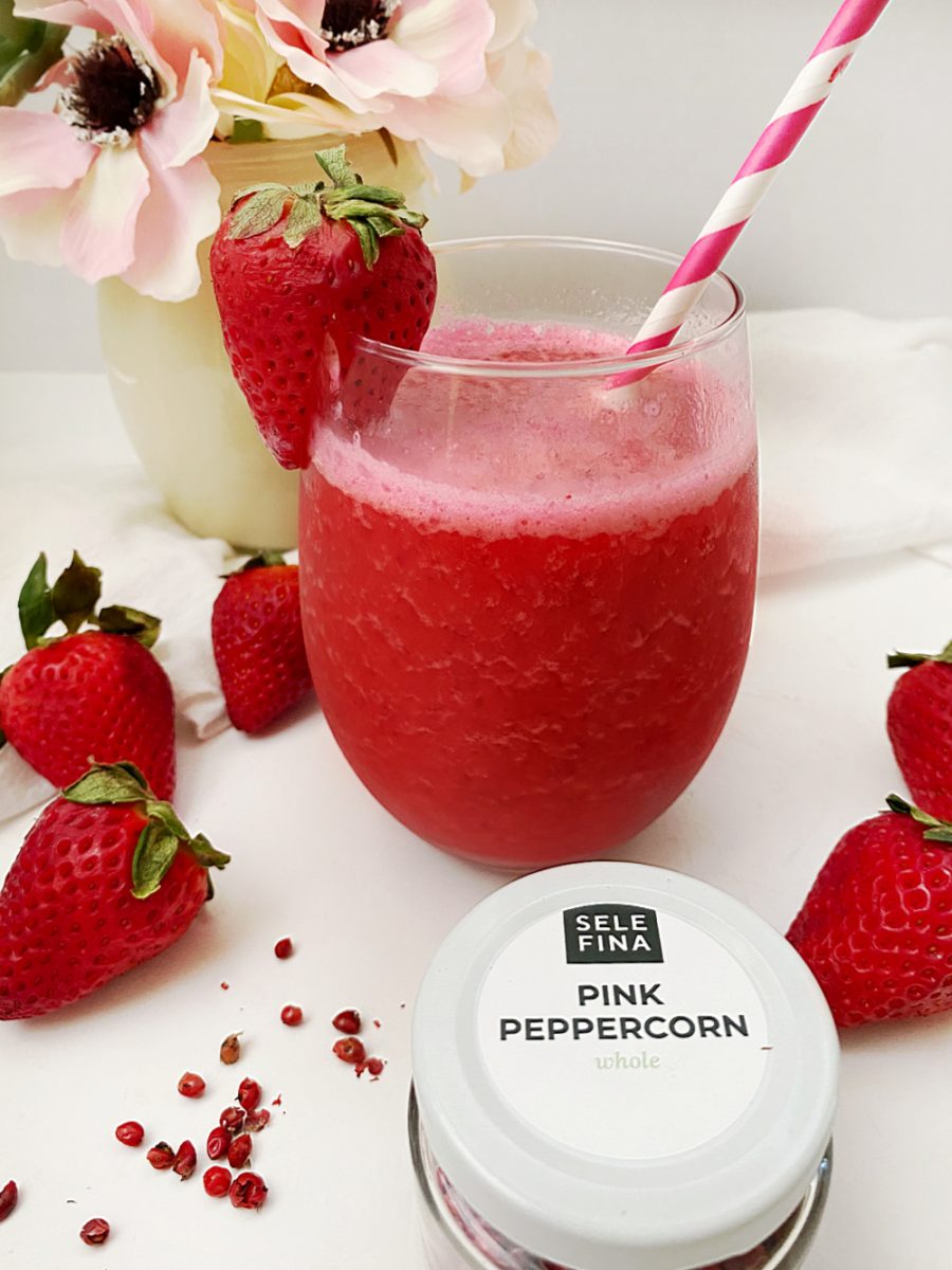 close up strawberry pink peppercorn breakfast smoothie in glass with straw