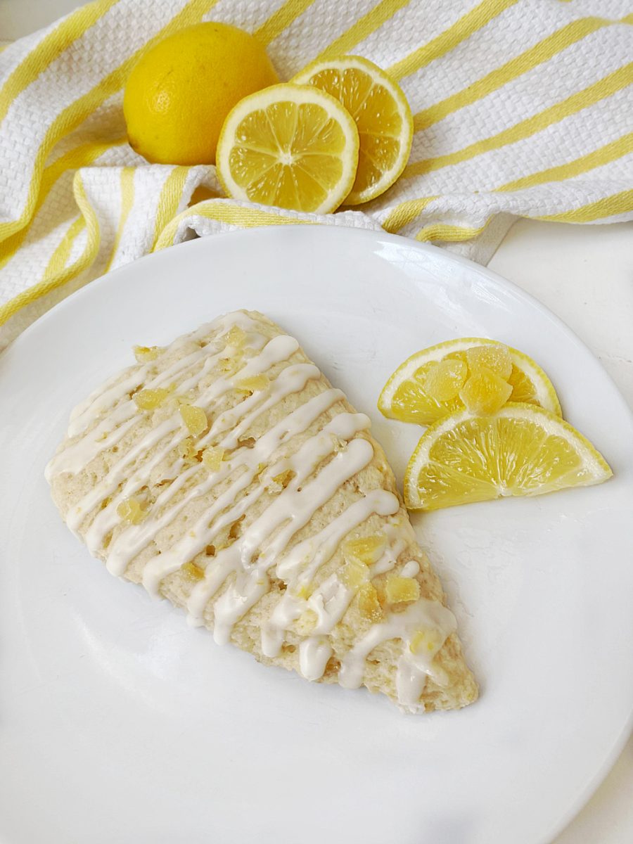 delicious lemon ginger scone on white serving plate with lemon and ginger pieces