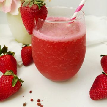 glass of strawberry pink peppercorn smoothies with strawberry garnish