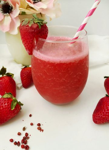 glass of strawberry pink peppercorn smoothies with strawberry garnish