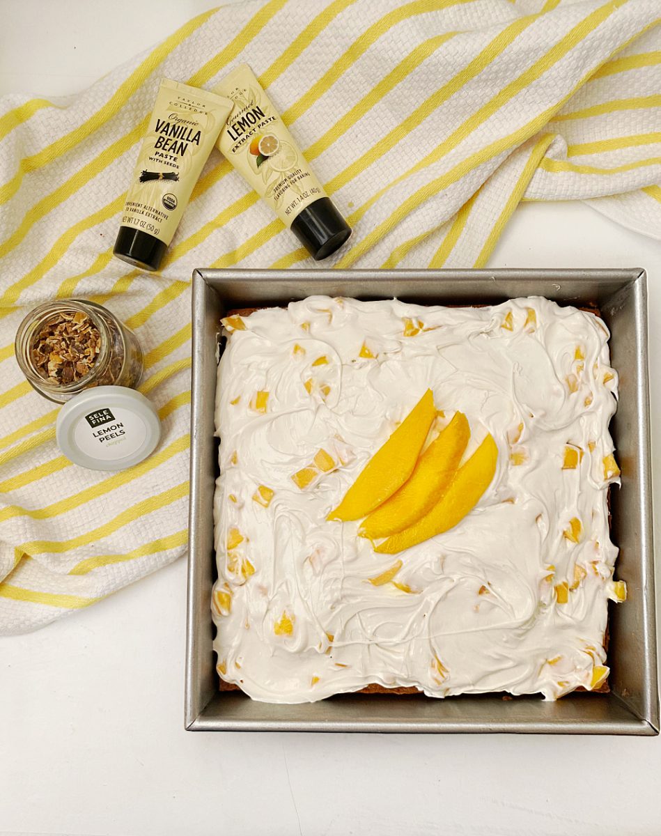 overhead view of mango coconut cake with sponsored items in background