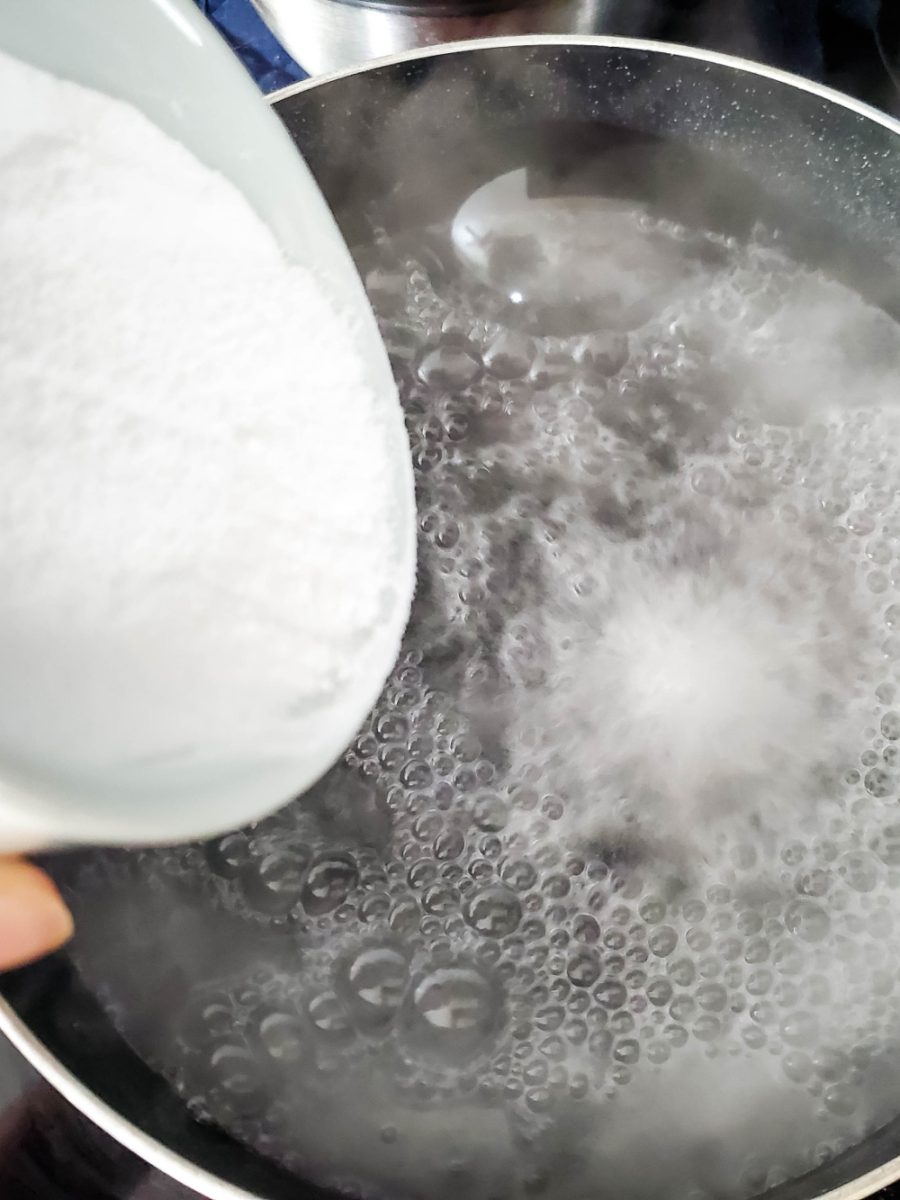 adding baking soda to boiling water in pot