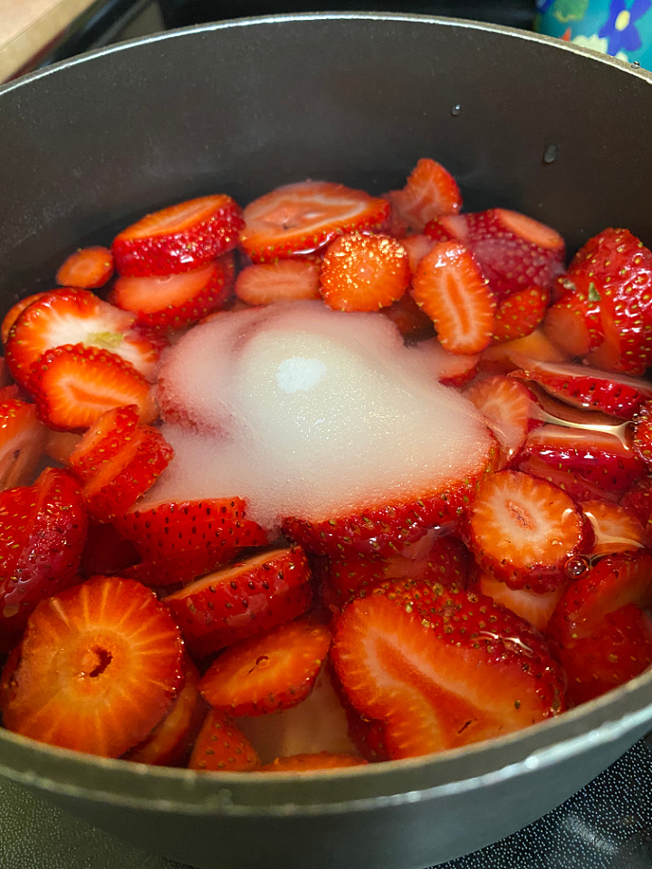 saucepan filled with strawberries and sugar to make strawberry syrup for tea