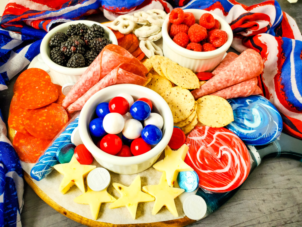 cheese stars, meats, fruits and candy on patriotic charcuterie board