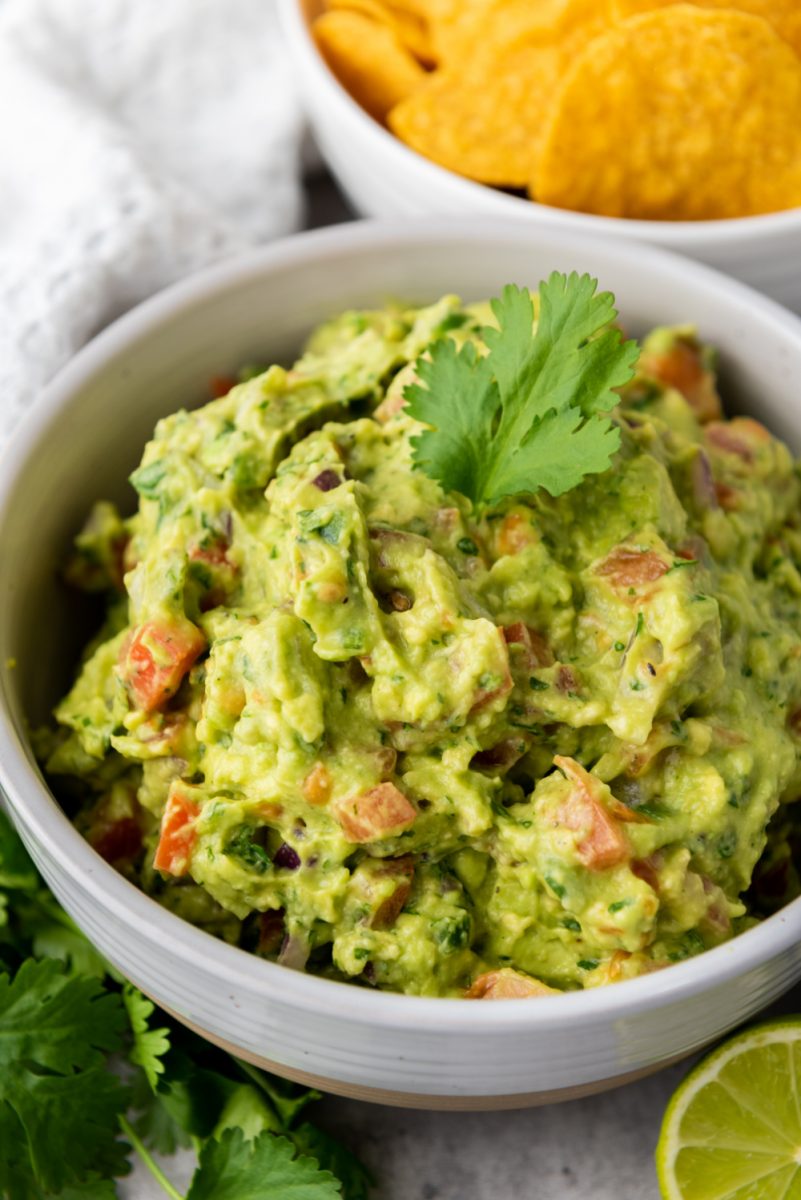close up of homemade guacamole in white bowl