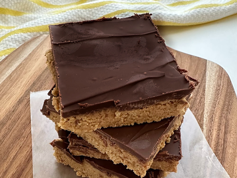 close up of no bake chocolate peanut butter bars on serving board