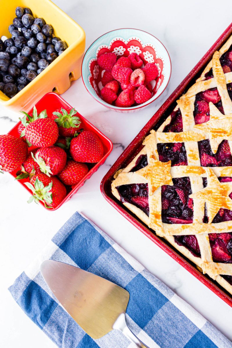 mixed berry pie overhead view with fresh berries in background